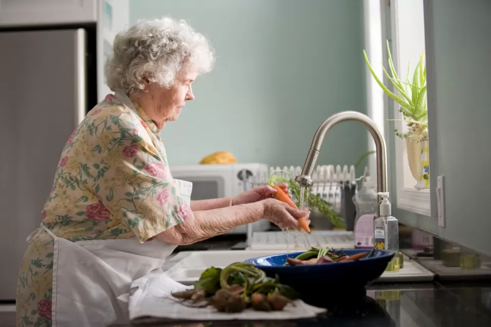 Senior Woman Washing Vegetables